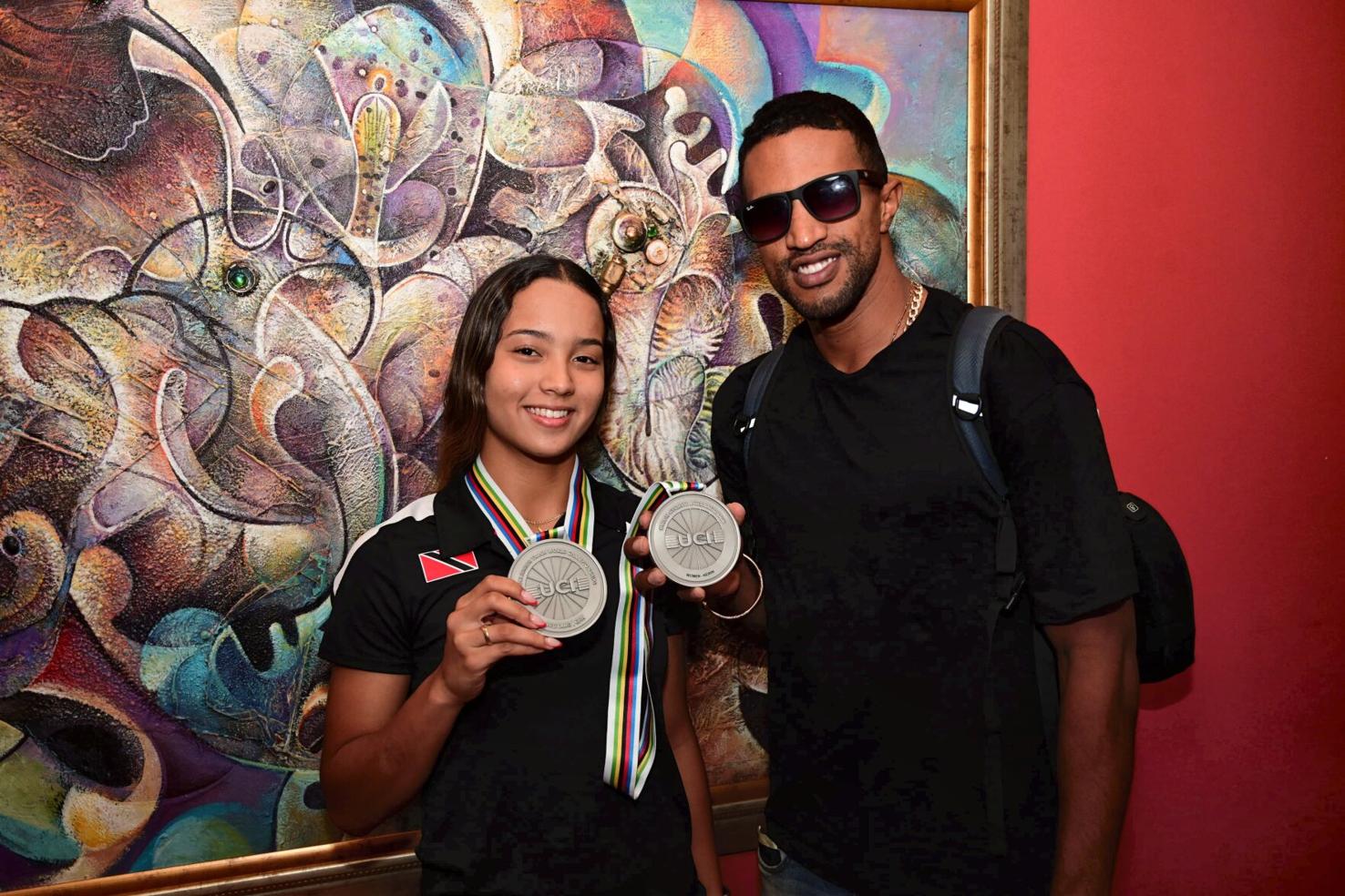 SILVERWARE: TTO cyclist Makaira Wallace and her primary coach, Njisane Phillip, display her two silver medals won at the UCI Junior Track World Championships in Luanyang, Chiina, last week. Wallace was second in the women’s 500m time-trial and runner-up in the keirin event. --Photo: JERMAINE CRUICKSHANK (Image obtained at trinidadexpress.com)